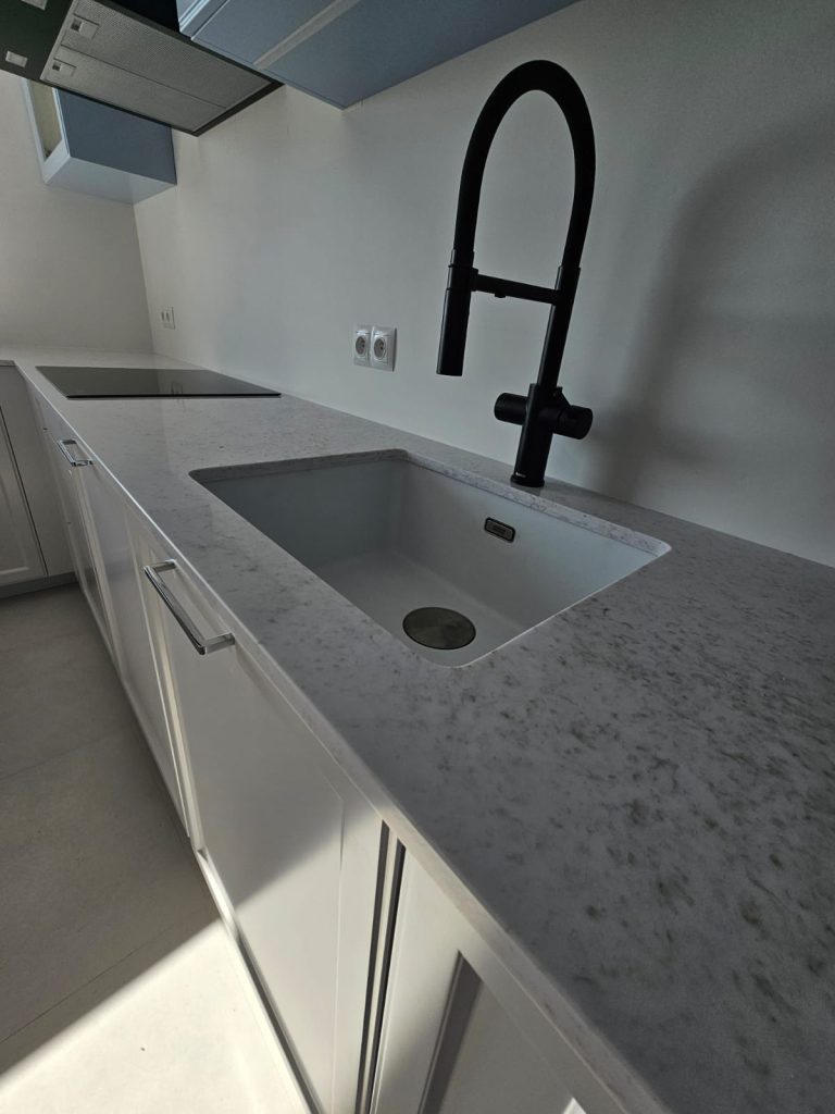 blaty kuchenne z konglomeratu Wedding Lily - widok na zlew podwieszan oraz płytę indukcyjną