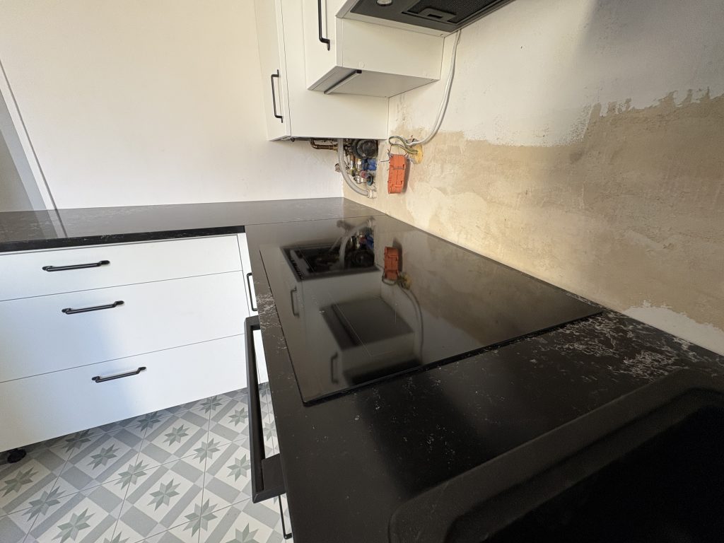 kuchnia wykończona blatami z konglomeratu Pearl Lava 3cm - widok na indukcję