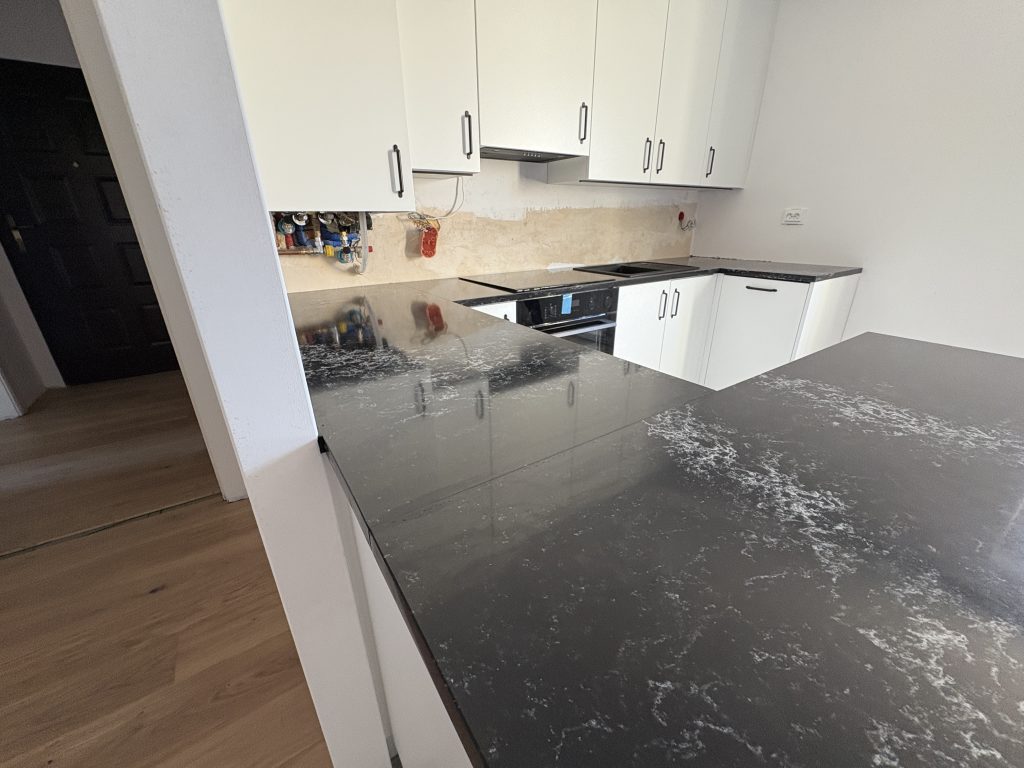 kuchnia wykończona blatami z konglomeratu Pearl Lava 3cm - widok na całość z lewej strony