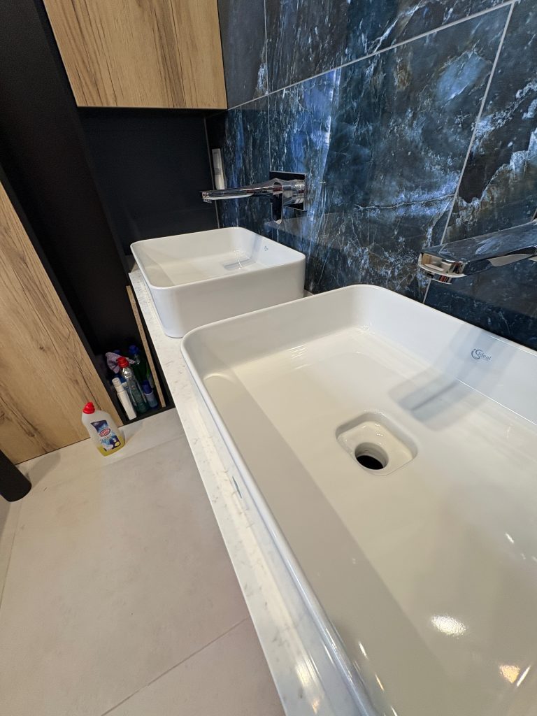 Jasny kamienny blat łazienkowy - widok na dwie umywalki