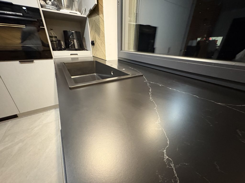 kuchenne blaty z konglomeratu nero venato w satynie - widok na blat ze zlewem nakładanym