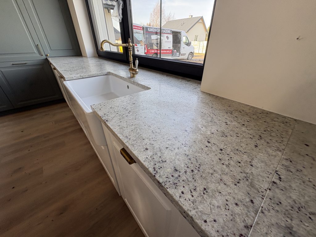 blaty kuchenne z granitu Colonial White - widok na blat z parapetem i otworem na zlew farmerski z prawej strony