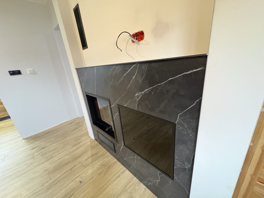 kominek wykończony spiekiem Calacatta Black Bocciardato - widok z prawej strony