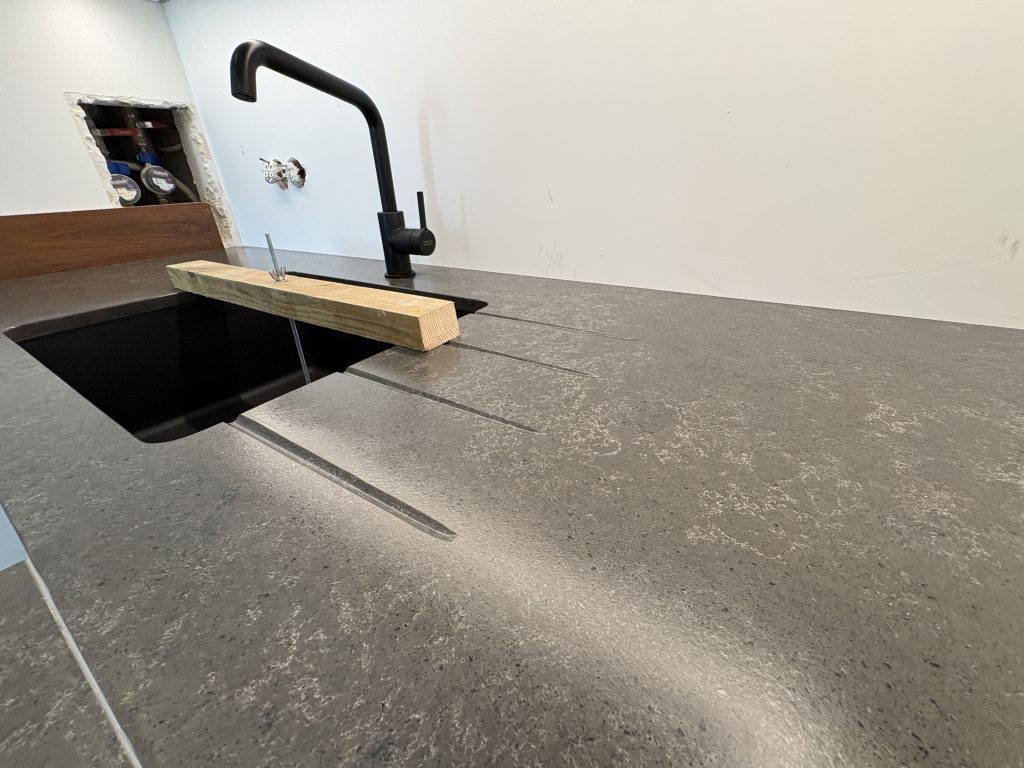 matowe blaty z konglomeratu Cassis - widok na ociekacz w formie ryfli przy otworze na zlew podwieszany