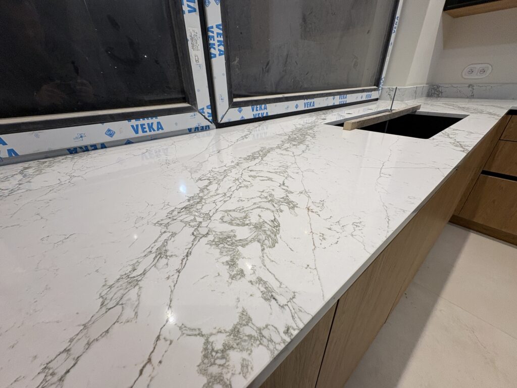 kuchnia wykończona konglomeratem Verde Peak - widok na blat z parapetem oraz zlew podwieszany