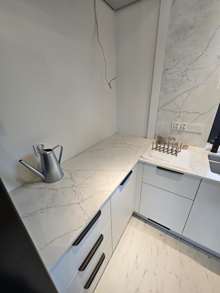 kuchnia wykończona blatami i okładzinami ściennymi z konglomeratu Calacatta Concorde - widok na mały blat roboczy